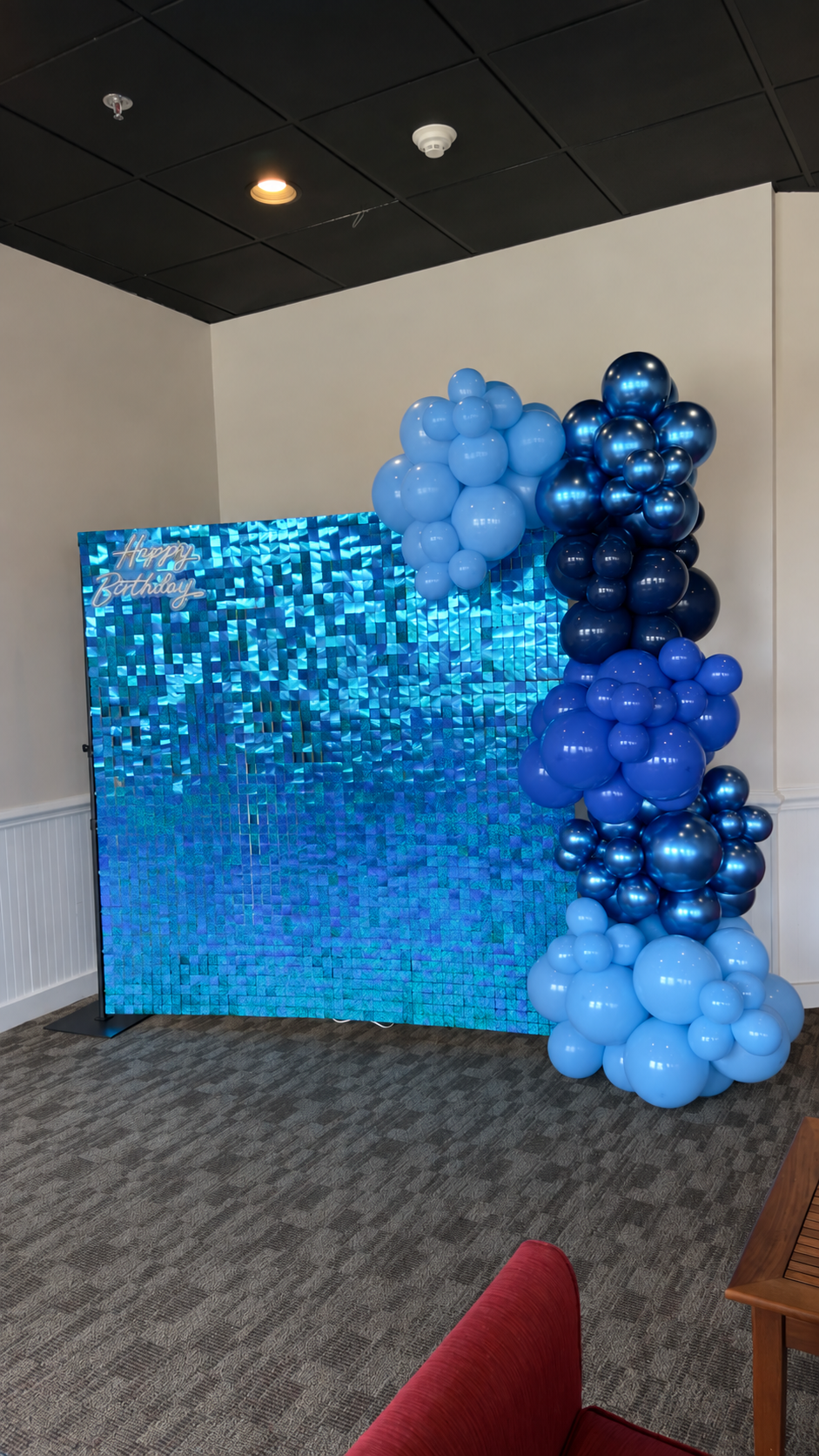 Blue organic balloon garland on a blue shimmer wall backdrop